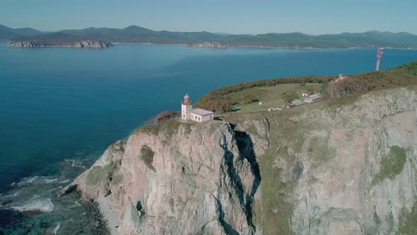 Aerial Panoramic View of White Lighthouse on the Rocky Cliff at Seaside