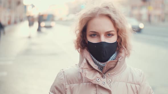 Portrait of a European Blonde with Curly Hair Wearing Protective Mask Street.