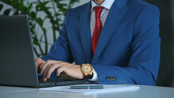 Businessman Sitting In Modern Office And Typing On Laptop Computer.