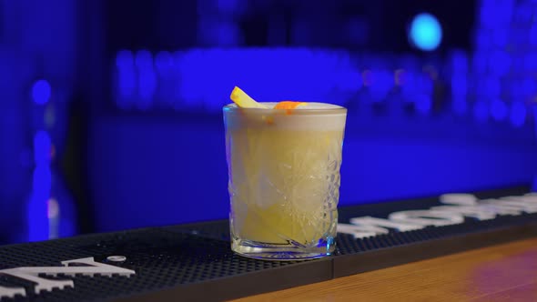 Bartender Squeezes Orange Rind Into a Glass with a Cocktail Then Puts the Rest Into the Glass Close