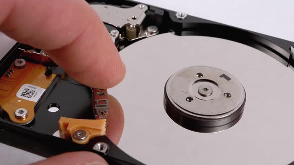 Finger Touches To the Recording Head Open Hard Drive. Hard Disk Drive Inside