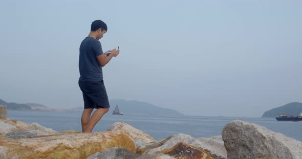 Asian man fly a drone at outdoor