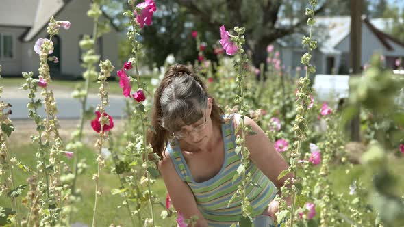 Hippie woman working in flowers looking up and smiling