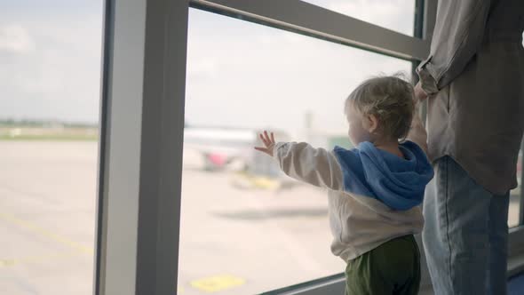 Closeup of Attractive Young Mother and Little Daughter Looking Out Window Airport Terminal with