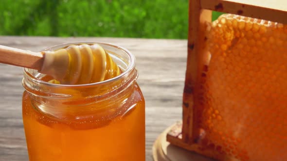 Honey Dipper Is Collecting Delicious Honey From a Glass Jar 