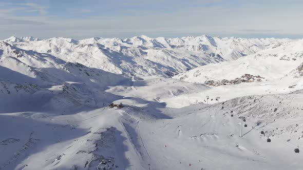 Drone View of Distant Cableway and Hut Located on Ski Resort in Snowy Mountain Ridge on Sunny Day in