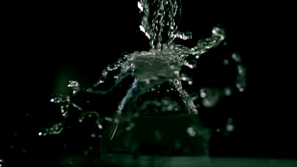Water pouring from a faucet in ultra slow motion 