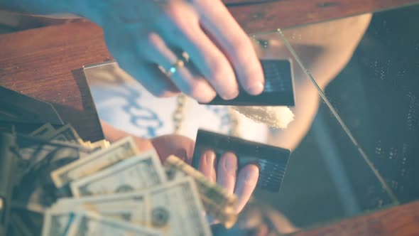 Addict prepares cocaine lines. The cocaine powder is sorted. The concept of drug abuse.