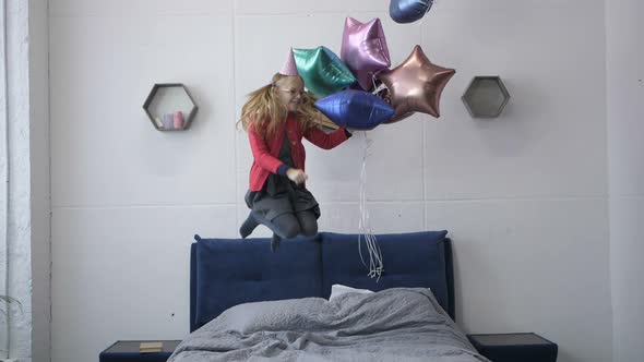  of Girl Jumping on Bed with Baloons