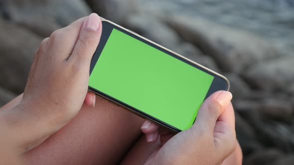 Close-up  female on the beach holds green screen phone 3840X2160 UHD video - Woman with chroma key d