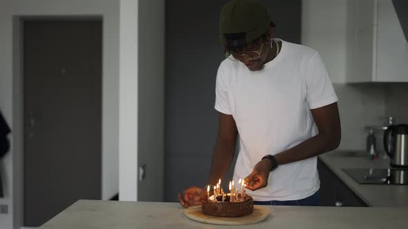Young Black Man Celebrating His Birthday at Home Lighting Candles