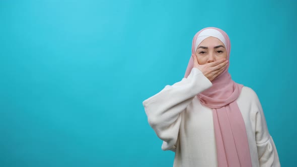 Sad and Serious Muslim Woman in Hijab Shaking Head Expressing No with Hand Over Mouth