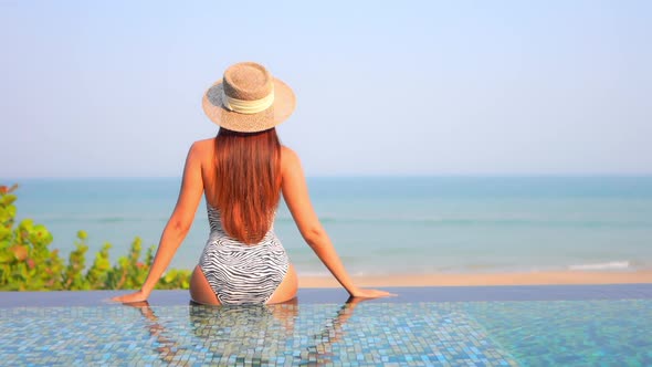 Young asian woman enjoy around outdoor swimming pool for leisure