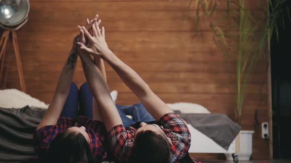 Beautiful Enamored Couple are Touching by Each Other's Hands in the Bedroom 