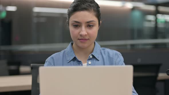 Close Up of Indian Woman Looking at Camera While Using Laptop