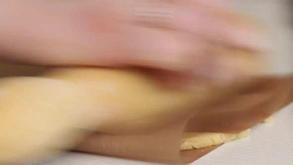 A Woman Rolls Out The Dough Wrapped In A Non Stick Mat.