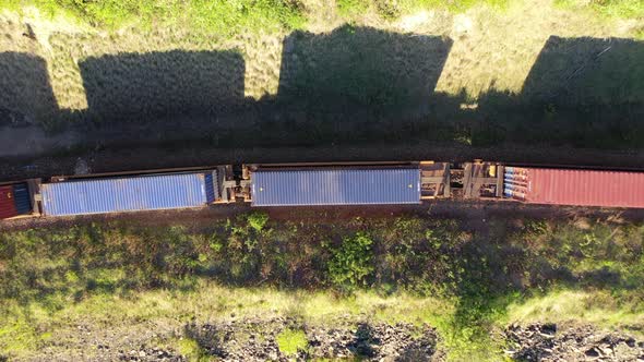 Aerial view of freight train passing by a river