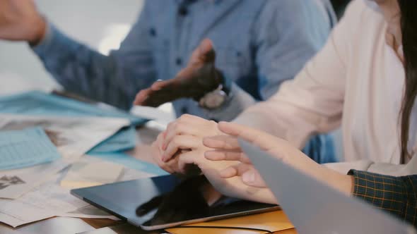 Close-up Busy Mixed Race Business People Collaborate and Discuss Work Over Office Table with Devices