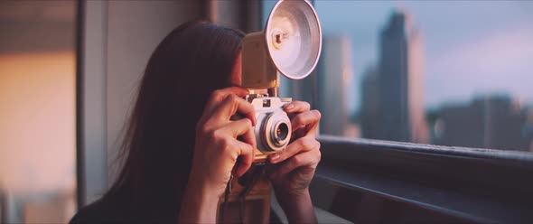 Woman photographer taking a picture of a skyline during sunset, smiling