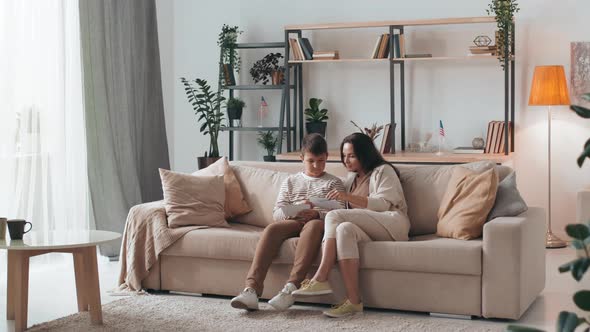 Mother and Son Looking at Photos in Living Room