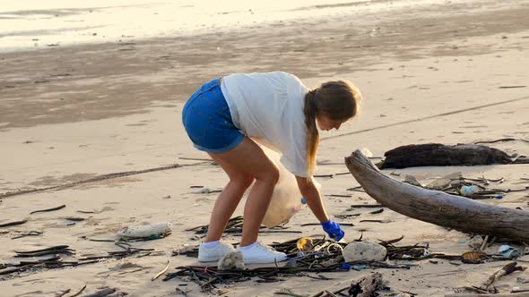 Woman Volunteer Collect Trash From the Sea Beach in a Trash Bag
