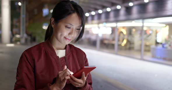 Woman use of mobile phone in city at night