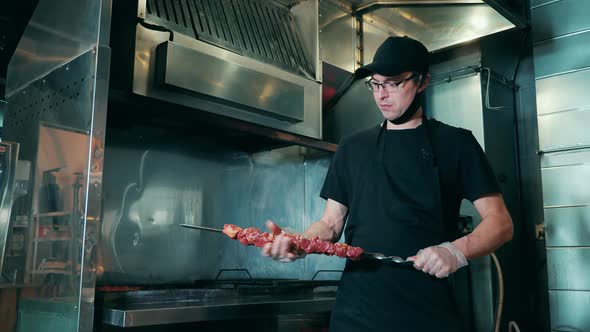 Male Cook is Preparing Meat on a Skewer for the Barbecue