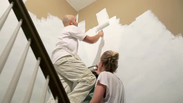 Couple painting wall