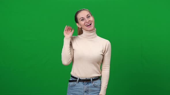 Middle Shot of Positive Woman Waving Goodbye Looking at Camera Smiling on Green Screen