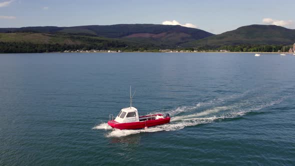 A Small Passenger Ferry at Sea Motoring Alongside an Island