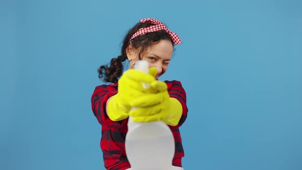 Happy Housewife Shooting to Camera with Spray Detergent Like From Weapon Blowing on It and Smiling