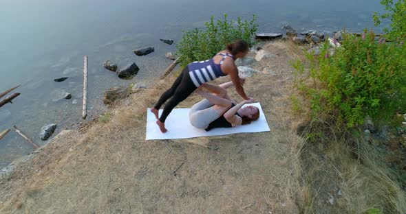 Couple practice acroyoga near lakeside 4k