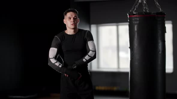 Athletic Young Man Boxer Walks Up to the Camera and Takes Off His Sportswear