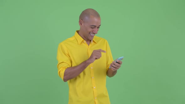 Happy Handsome Bald Businessman Thinking While Using Phone