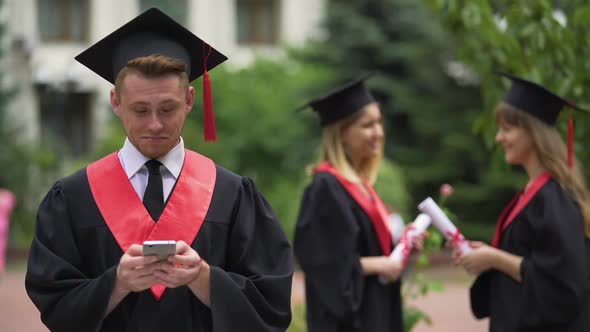 Graduate Checking Job Offers on Smartphone, Reading Messages in Social Network