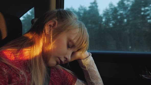 Blonde Girl Dozing in a Car Sitting By the Window