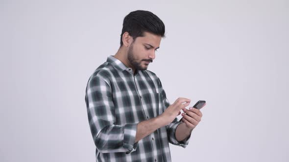 Young Bearded Indian Man Using Phone and Looking Shocked