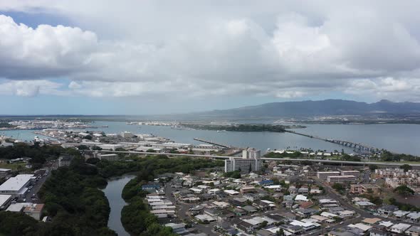 Super wide aerial shot of Pearl Harbor with the USS Arizona Memorial in the background on the island