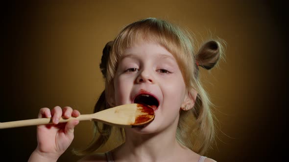 Playful Teen Child Kid Girl Eating Licking Melted Chocolate Sweet Candy Syrup From Wooden Spoon
