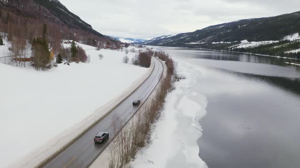Asphalt Road By The Lakeshore Of Steinsfjorden In Vik, Vestland County, Norway With Snowy Landscape