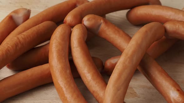 Thin long pork sausages on the wooden cutting board