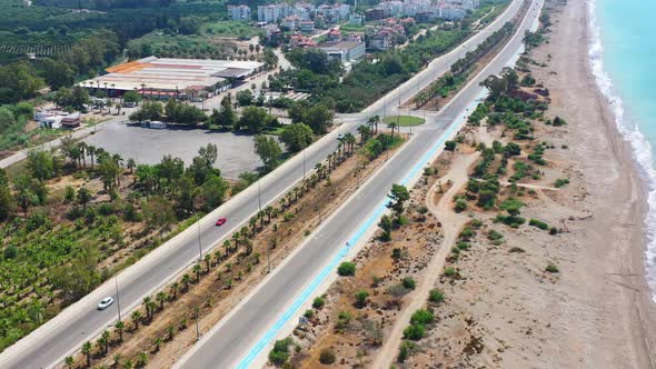 Aerial view of an empty coastal highway road in Finike Turkey on a sunny summer day with a sandy bea