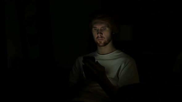 Redhead Man Using Smartphone at Night
