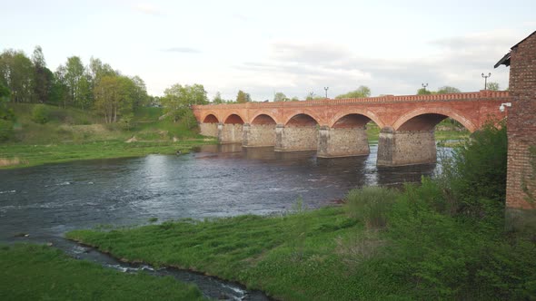 Long Old Brick Bridge, Kuldiga, Latvia Across the Venta River. 4K Stedycam Dolly Shot. The Widest Wa