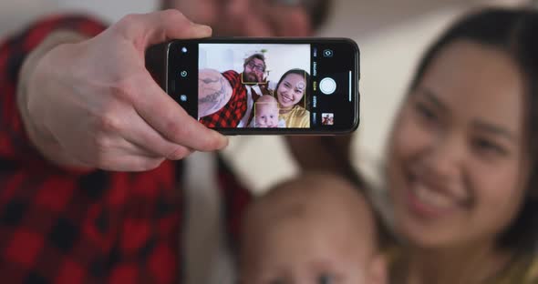 Young Couple Taking Selfie with Baby