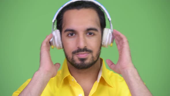 Young Handsome Bearded Indian Businessman Listening To Music