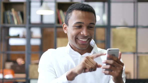 Black Man Using Smartphone in Office