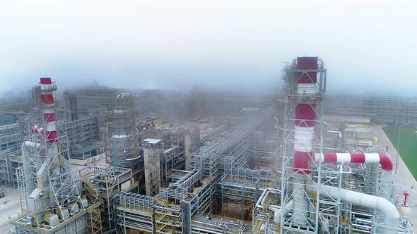 Aerial view of fog floating over refinery and industrial chimney. Drone footage