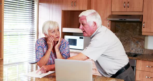 Senior couple arguing with each other in kitchen