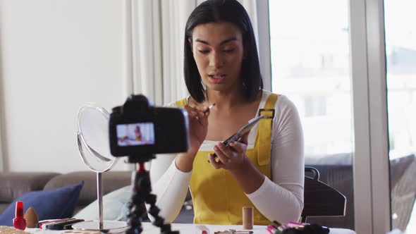 Mixed race gender fluid vlogger recording a make up vlog at home